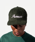 Person wearing a green cap with 'Primrose' embroidery on a white background