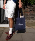 Man in shorts on street holding Primrose London tote bag