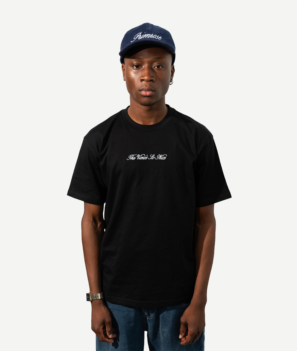 Person wearing a black t-shirt and navy cap on a white background